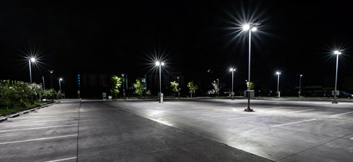 An empty parking lot with lights brightly illuminating the area