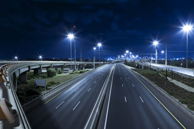 A highway at night being illuminated by bright LED street lights