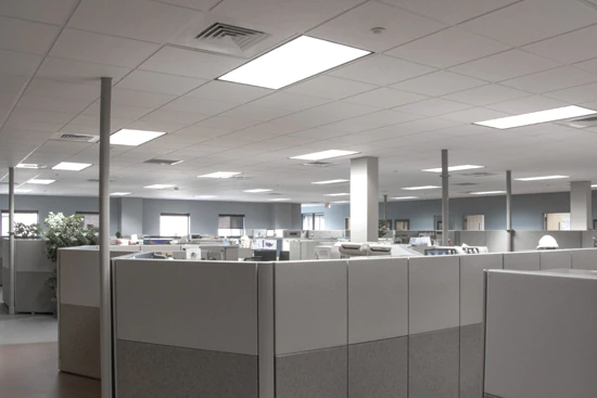 LED troffer lighting fixtures on the ceiling of an office building illuminating the entire office space