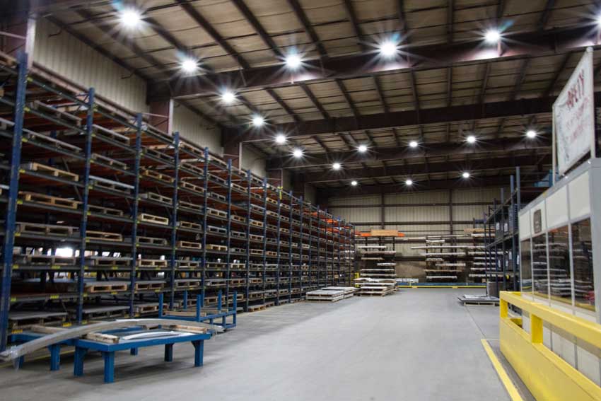 Inside a warehouse of an LED lighting company. The ceiling has bright LED lighting fixtures which are illuminating the entire area.